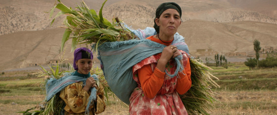 Women carry silage on their backs in the village of Tarart, in the High Atlas, Morocco August 30, 2006. Morocco has more citizens of Berber origin than any other country, and nearly 40 percent of the population speaks one of three Amazigh languages, but many Berbers accuse their compatriots of discrimination. Picture taken August 31, 2006. To match feature MOROCCO BERBERS REUTERS/Eve Coulon (MOROCCO)